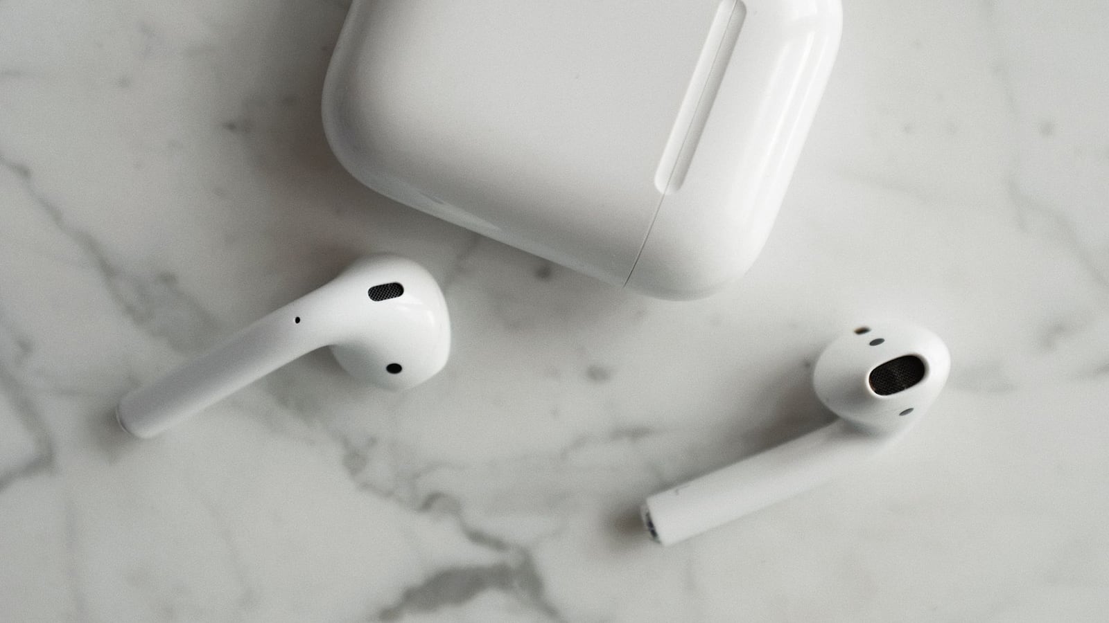 Smartphone and earbuds on a marble table, representing streaming audio