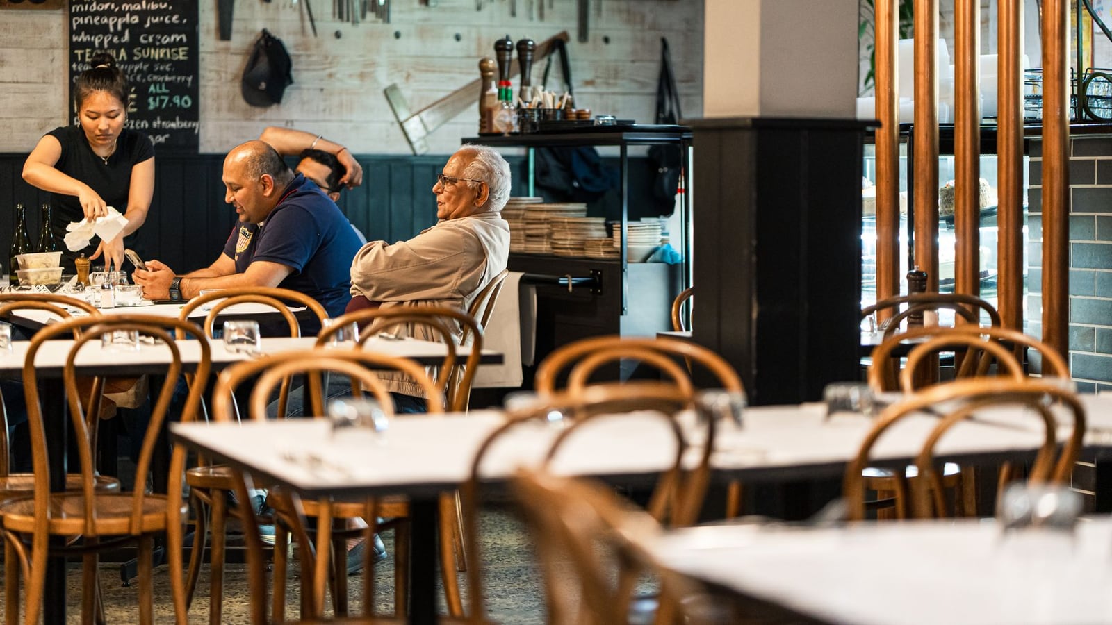 Two professionals discussing a music project in a bright Melbourne cafe