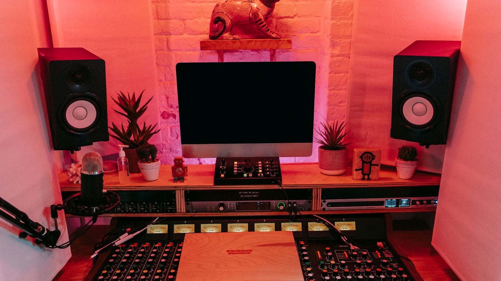 A cozy and modern home studio setup with monitors and a desk