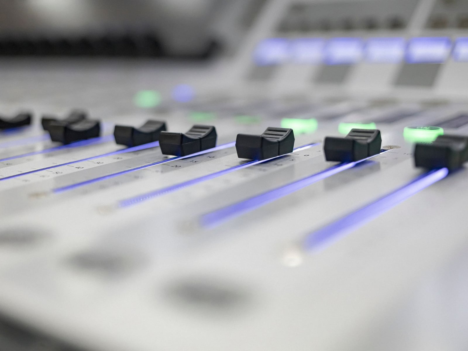 Close-up of an engineer's hand adjusting a fader on a professional mixing console